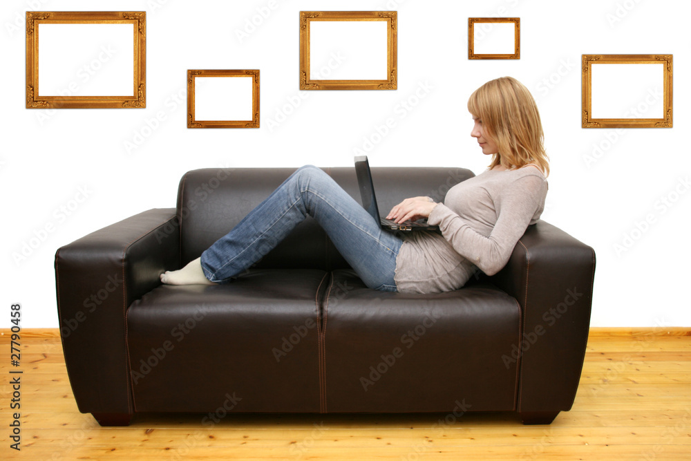 young woman lying on a sofa and using a laptop young woman lying on a sofa and using a laptop