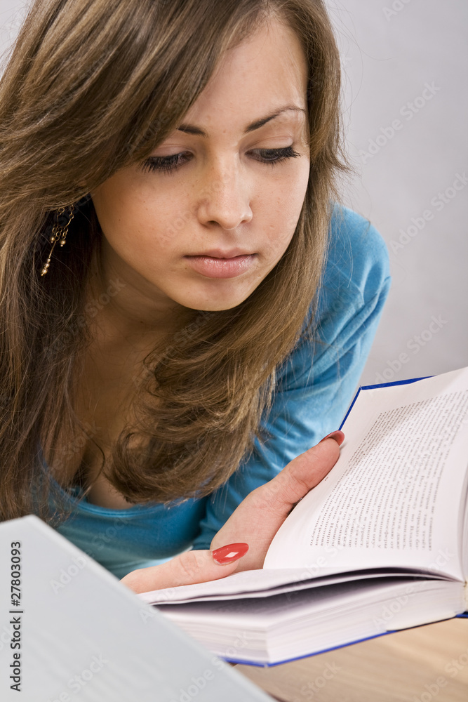 beautiful girl thoughtfully reading a book, surrounded by books beautiful girl thoughtfully reading a book, surrounded by books