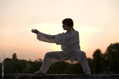 woman in white suit make's taiji chuan exercise photo