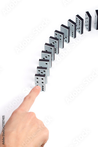 Obraz na plátně Hand pushing line of domino pieces