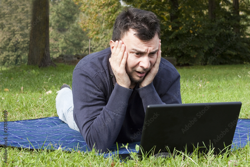 Young Adult Working in the Park with Laptop Computer Young Adult Working in the Park with Laptop Computer