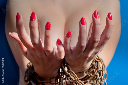 Red nails on girls hand on blue background photo