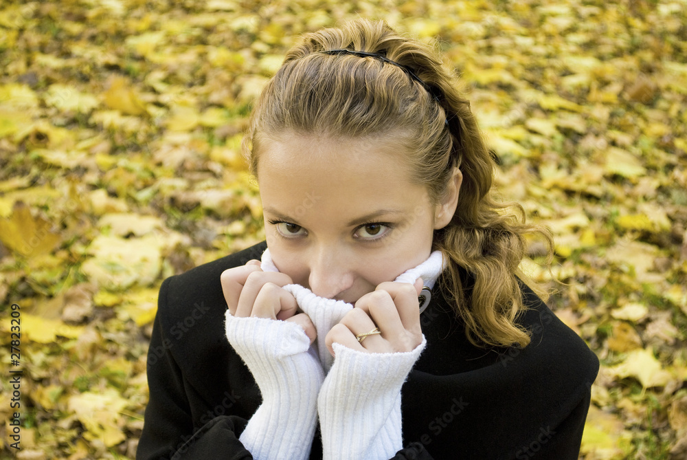 Teen girl warms herself in cold autumn park Teen girl warms herself in cold autumn park