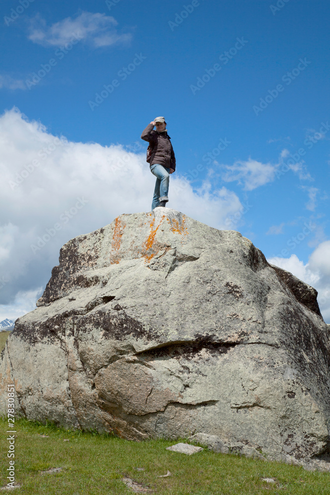 A young woman climbs on the cliff top