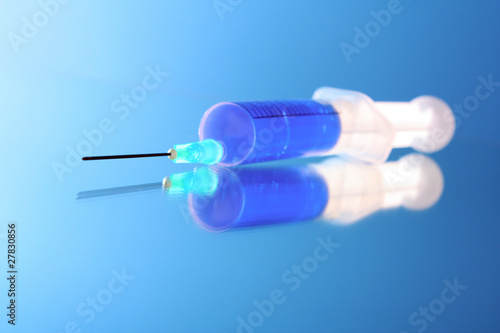 Syringe with reflection on blue background