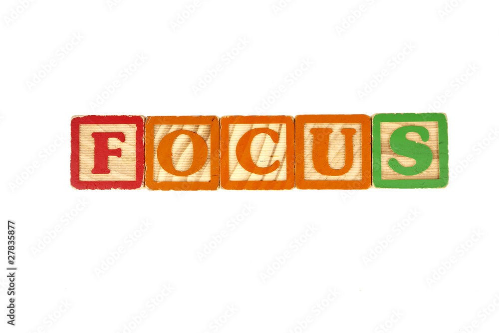 Old toy blocks used to spell out the word focus.