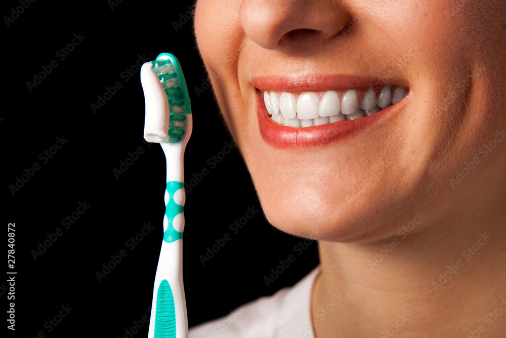 Woman healthy teeth closeup with toothbrush on black background Woman healthy teeth closeup with toothbrush on black background