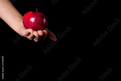 Woman holding red apple on black background