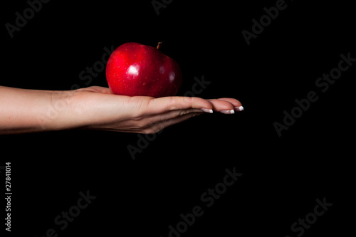 Woman holding red apple on black background