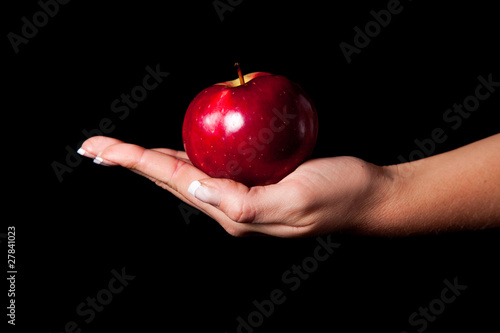 Woman holding red apple on black background