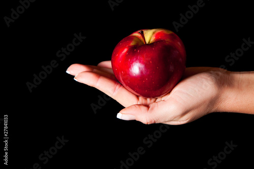 Woman holding red apple on black background