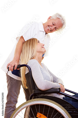 Krankenschwester redet mit Frau im Rollstuhl