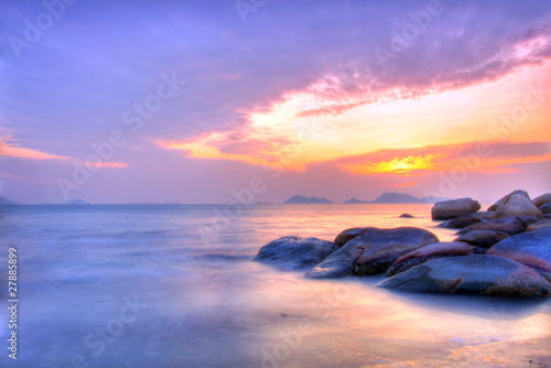 Sea and rock at the sunset under long exposure.