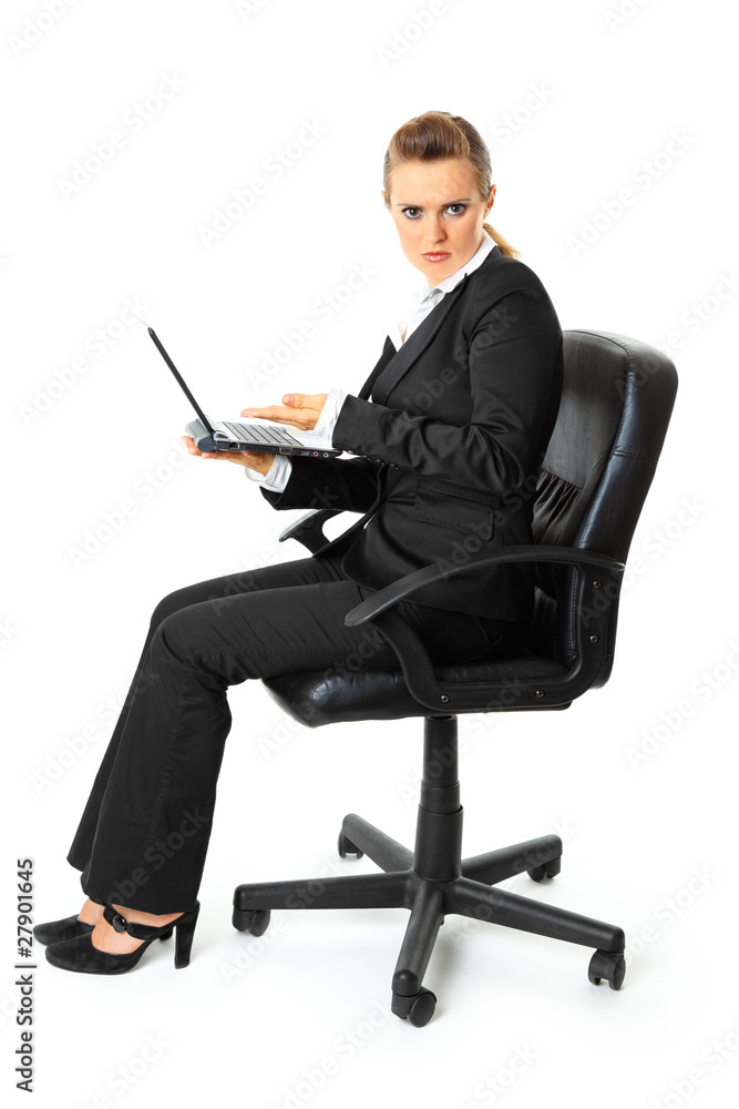 Displeased business woman sitting on chair and holding laptop Displeased business woman sitting on chair and holding laptop