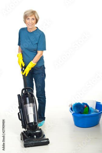 Senior woman using vacuum cleaner photo