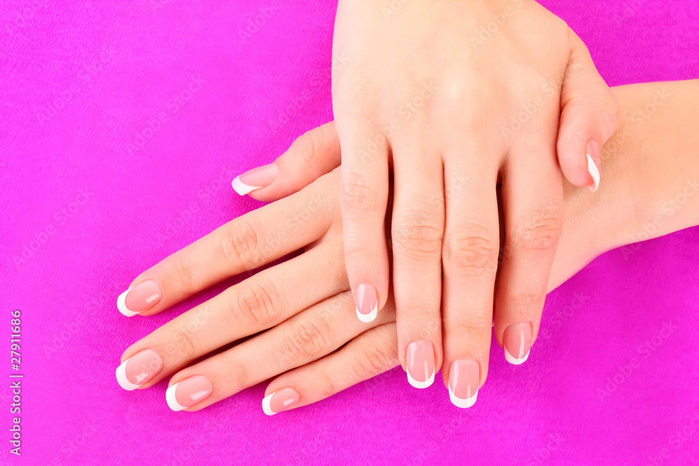 Fototapeta premium Beautiful woman hand with french manicure on pink background