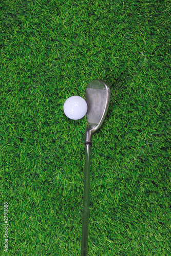 Golf ball and iron club on grass
