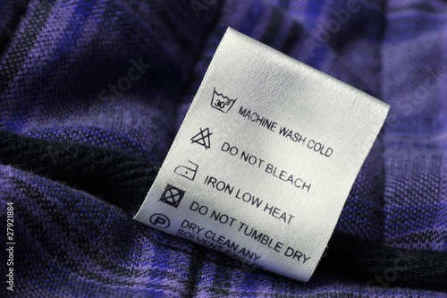 Laundry care label on scotch textile background