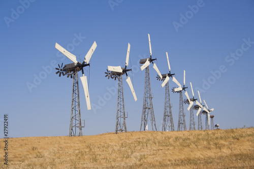 Many white wind turbine generating electricity on blue sky