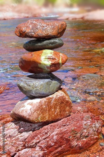 Rolling stones stacked red rodeno limestone in river photo