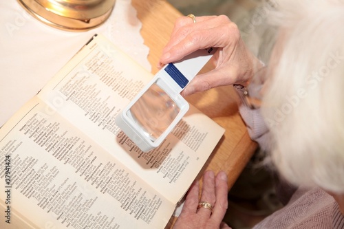 Frau schaut durch Lupe