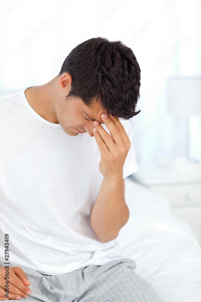 Attractive man having a headache and touching his forehead Attractive man having a headache and touching his forehead