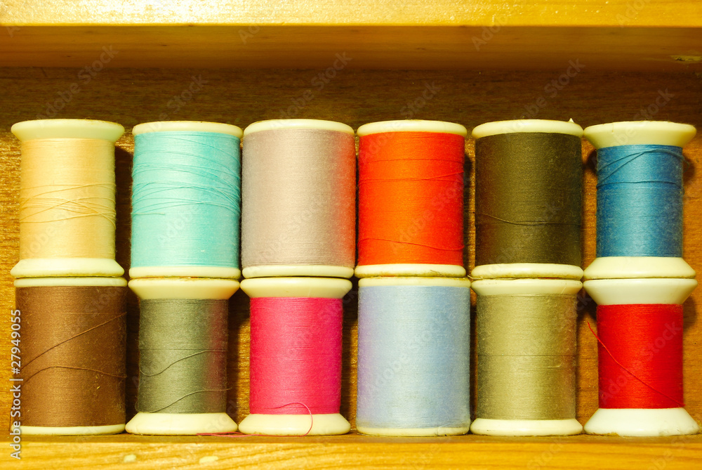colorful spool of thread on wood shelf colorful spool of thread on wood shelf