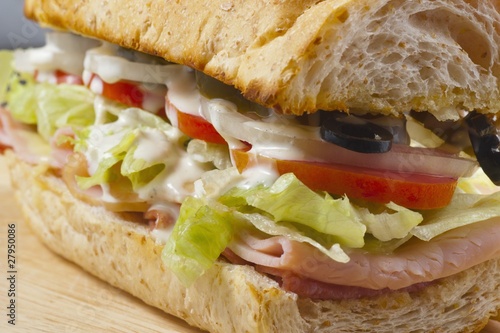 a sandwich with meat, vegetables and olives