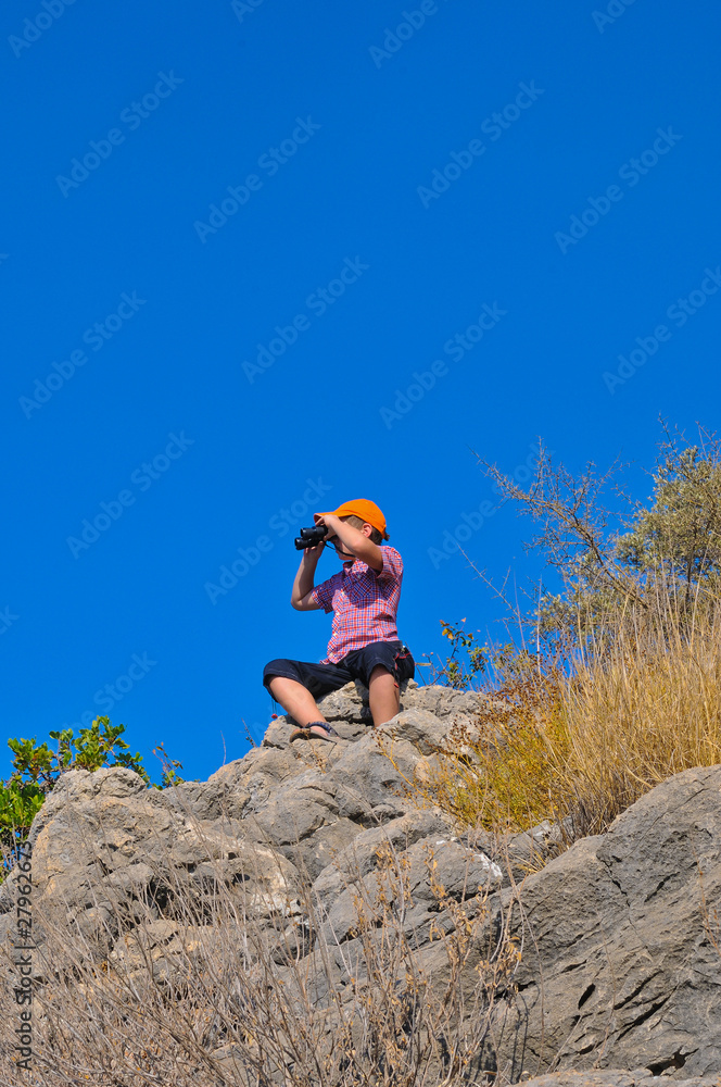 Fototapeta premium The boy with the glasses on the rocks