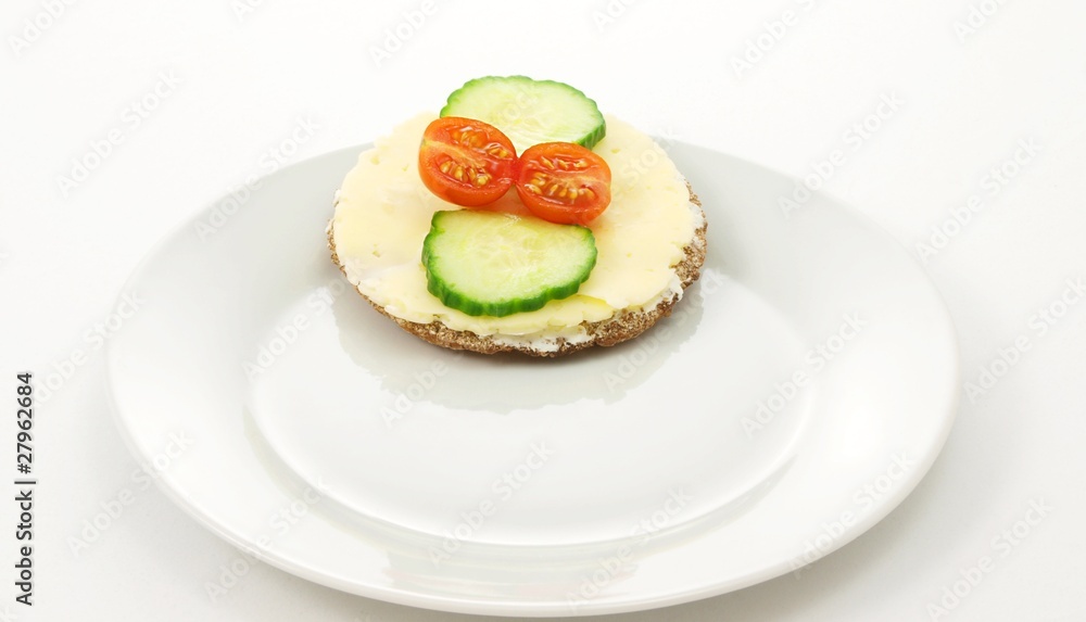 Cracker on plate, with tomato and cucumber, white background Cracker on plate, with tomato and cucumber, white background