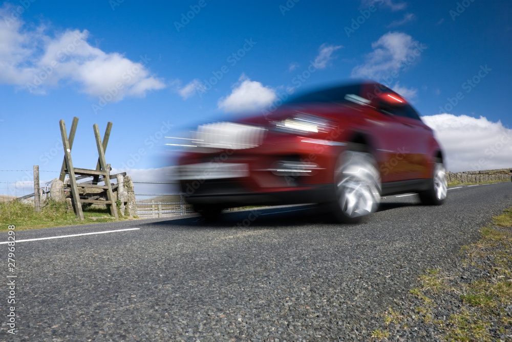 Red car speeding on empty mountain road