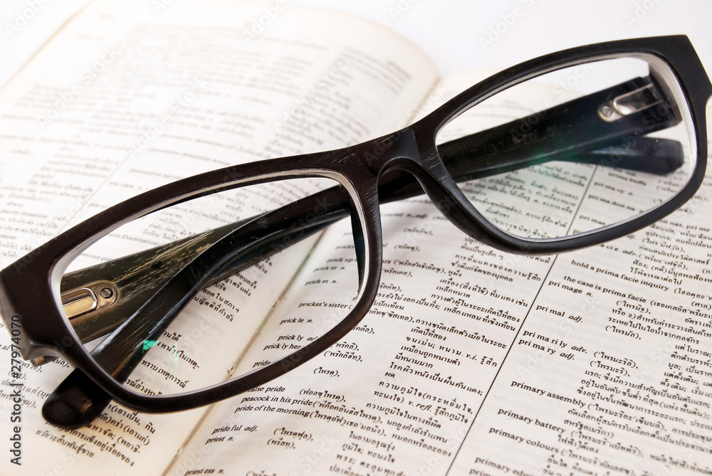 closeup of old dictionary and glasses closeup of old dictionary and glasses