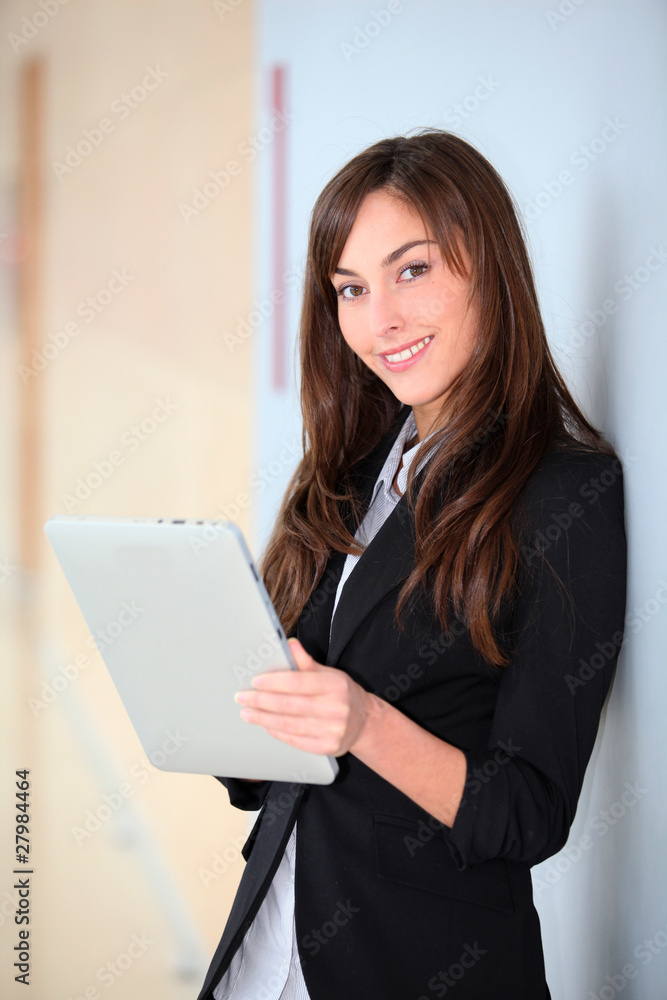 Businesswoman standing in hall with electronic pad Businesswoman standing in hall with electronic pad