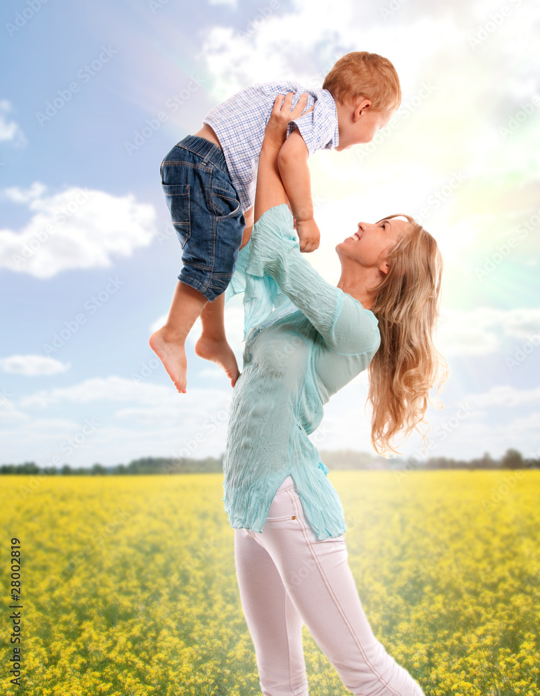 Portrait of happy mother with joyful son over sping flower field Portrait of happy mother with joyful son over sping flower field