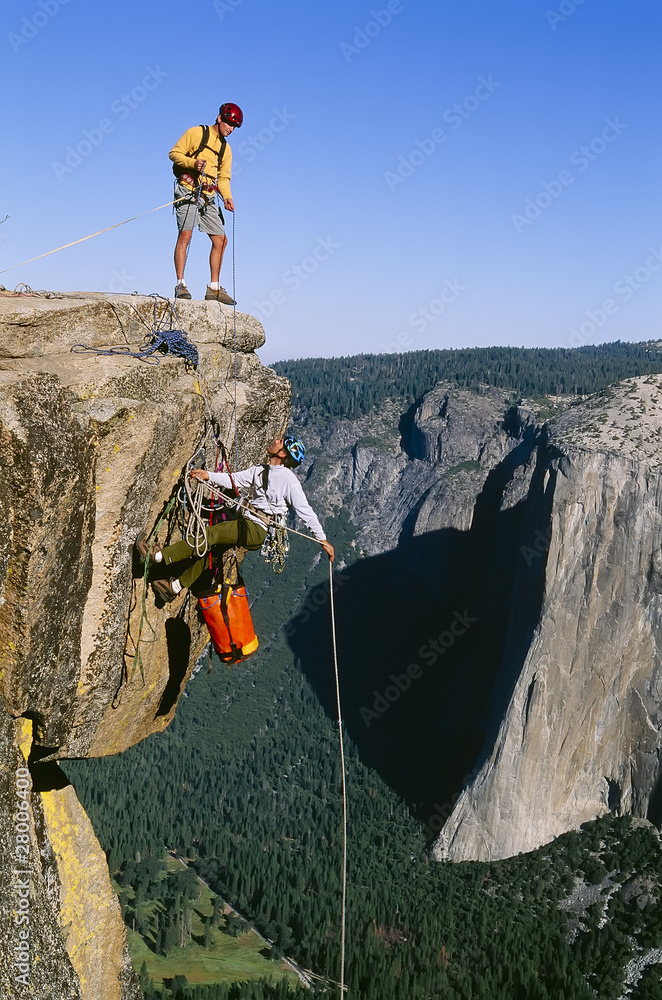 Fotografie Rock climbing team reaching the summit.