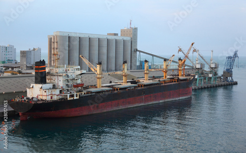 Big cargo ship docked to industrial port at evening in Abu Dhabi photo