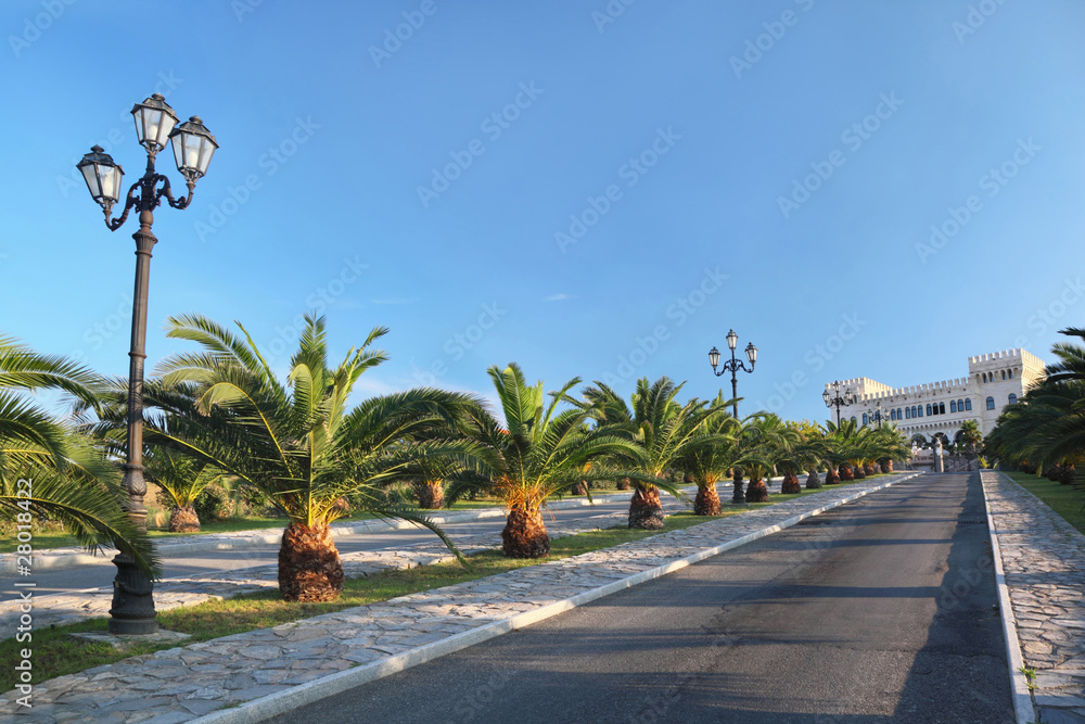 Fototapeta premium View on palace at end of street with palms and lanterns