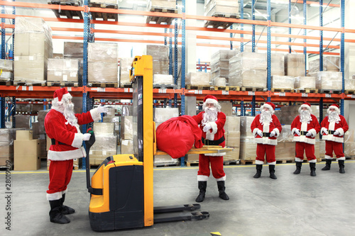 фотографія santa clauses in the line for the sacks of gifts in storehouse