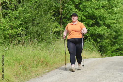 XXL-Model übergewichtige Frau beim Nordic Walking