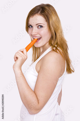 junge Frau ißt eine Möhre