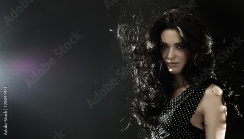 Portrait of a young beautiful brunette over black