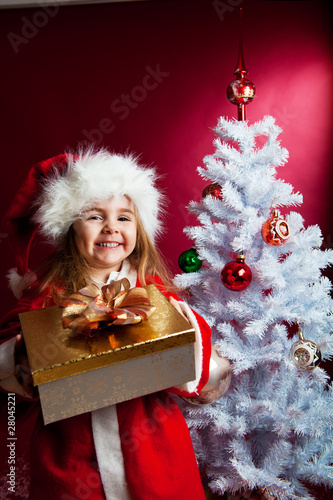 Photography Kind mit dem Geschenkbox unter dem Christbaum