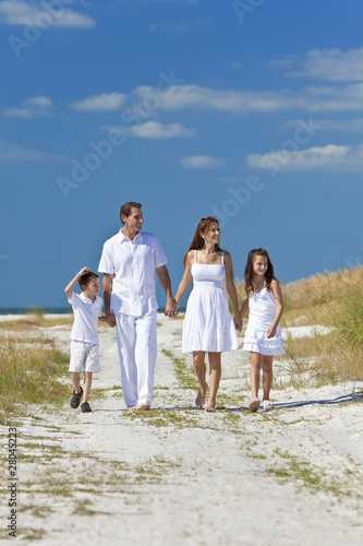 Mother, Father and Children Family Walking On Beach