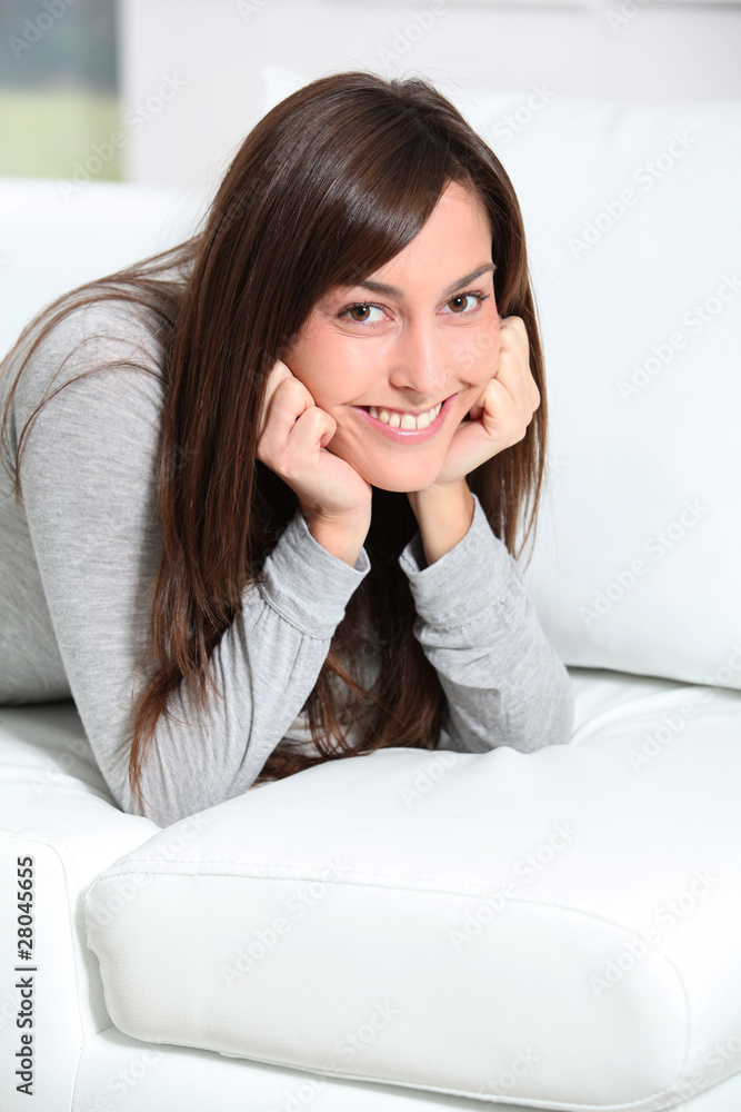 Smiling young woman laying on sofa Smiling young woman laying on sofa
