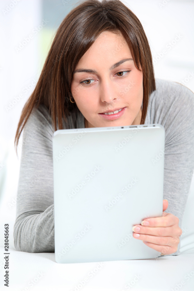 Young woman laying on sofa with electronic pad Young woman laying on sofa with electronic pad