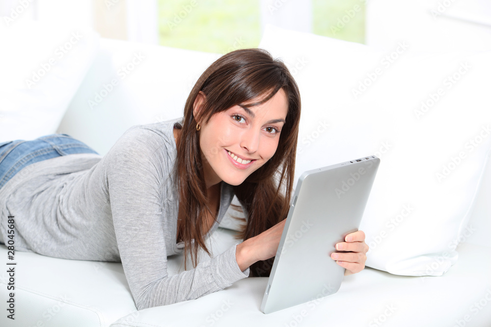 Young woman sitting on sofa with electronic pad Young woman sitting on sofa with electronic pad