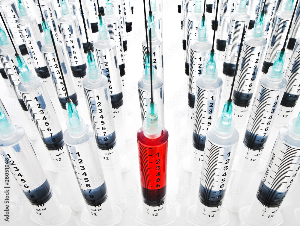 Rows of syringes, one filled with blood Rows of syringes, one filled with blood