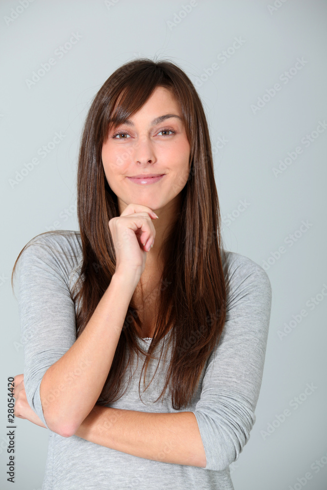 Young woman looking at camera with hand on chin Young woman looking at camera with hand on chin
