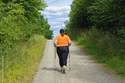 XXL-Model übergewichtige Frau beim Nordic Walking