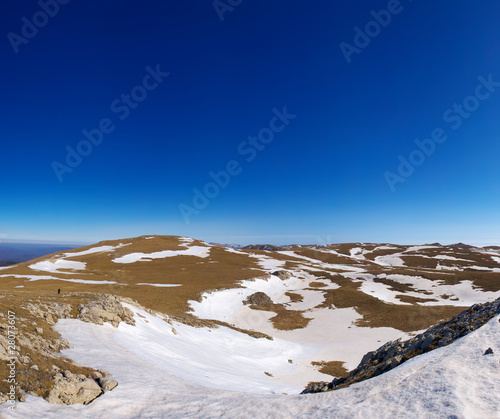 Hills with snow on background clean blue sky